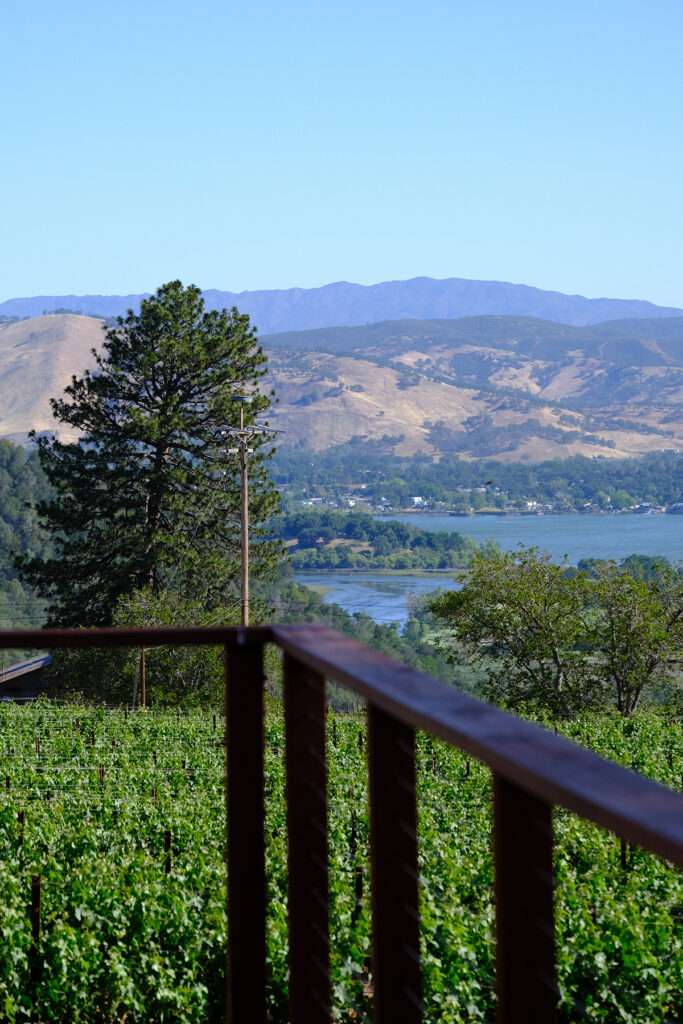 a view of a lake and mountains from a deck.